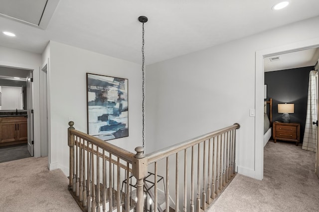 corridor with carpet flooring, visible vents, an upstairs landing, and recessed lighting