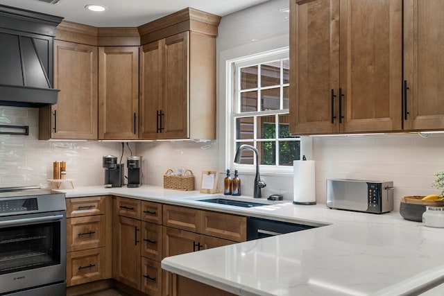 kitchen featuring backsplash, stainless steel electric range oven, range hood, and a sink