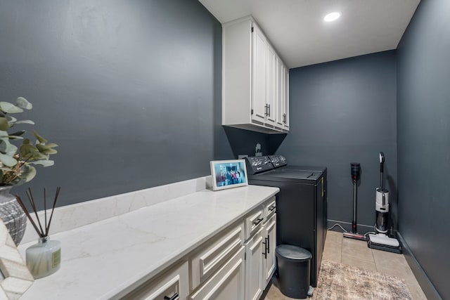 laundry room with baseboards, cabinet space, light tile patterned floors, and independent washer and dryer