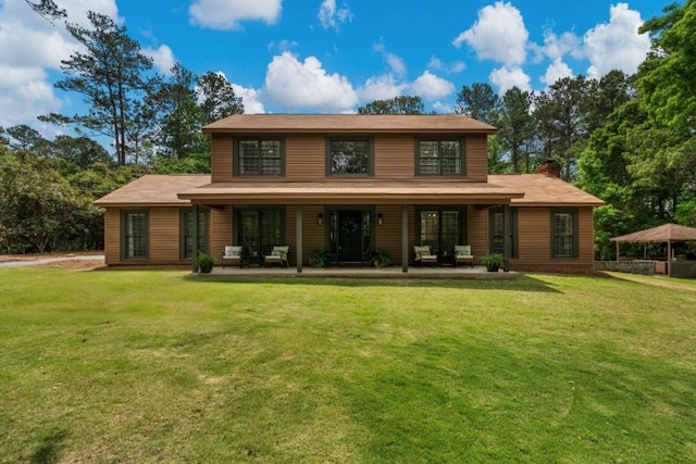 rear view of property with a chimney and a lawn