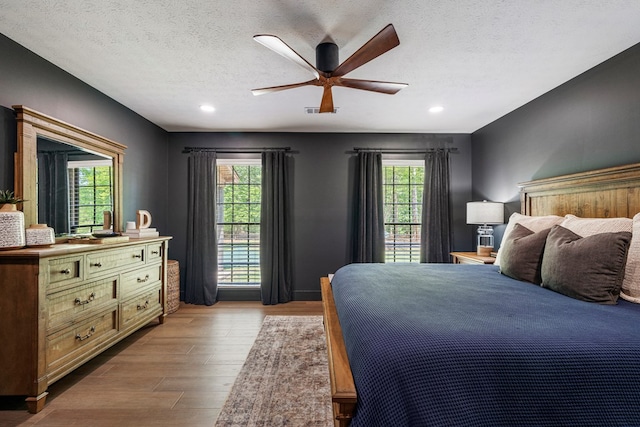 bedroom featuring multiple windows, recessed lighting, and wood finished floors