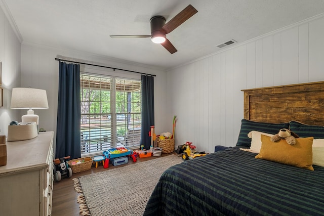 bedroom with ceiling fan, ornamental molding, visible vents, and wood finished floors