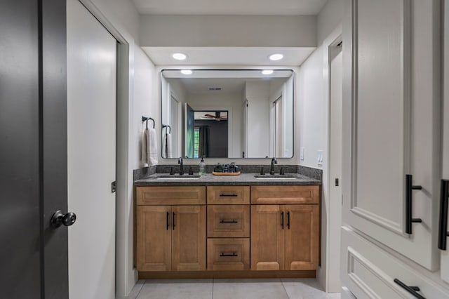 full bath featuring tile patterned flooring, visible vents, double vanity, and a sink