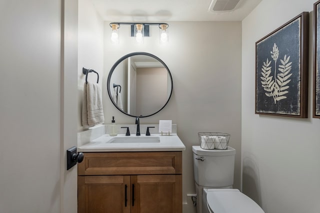 bathroom featuring vanity, toilet, and visible vents
