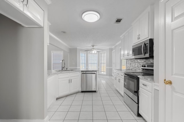 kitchen featuring stainless steel appliances, light tile patterned floors, white cabinets, ceiling fan, and sink