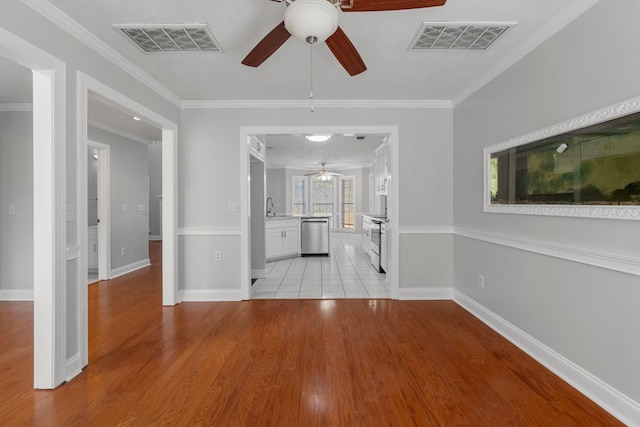 interior space featuring light wood-type flooring, ceiling fan, ornamental molding, and sink