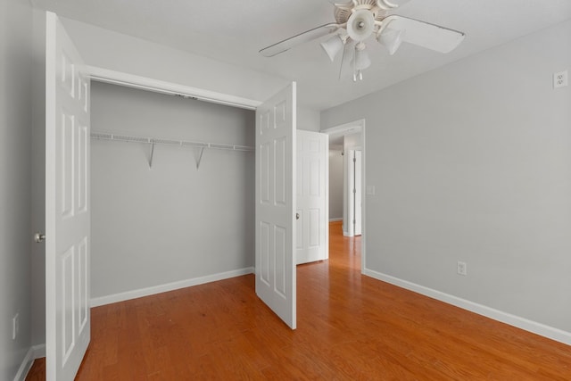 unfurnished bedroom with hardwood / wood-style flooring, ceiling fan, and a closet