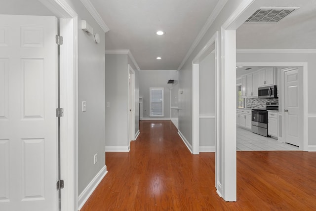 hall featuring light wood-type flooring and crown molding