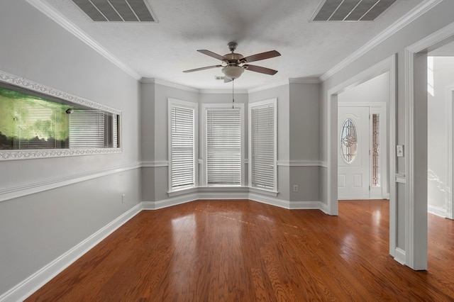 empty room with hardwood / wood-style flooring, a textured ceiling, ceiling fan, and crown molding