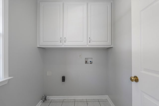 washroom with washer hookup, light tile patterned floors, cabinets, and hookup for an electric dryer