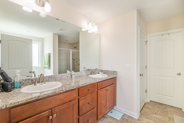 full bathroom featuring a stall shower, double vanity, and baseboards