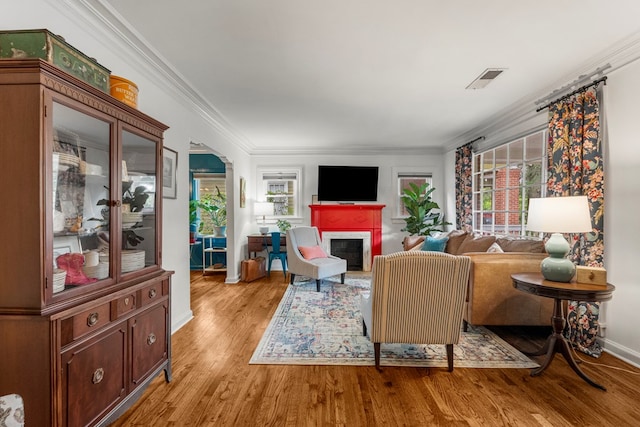 1445 22nd St, Columbus, GA 31901 - living area featuring a fireplace, light wood finished floors, ornamental molding, and arched walkways