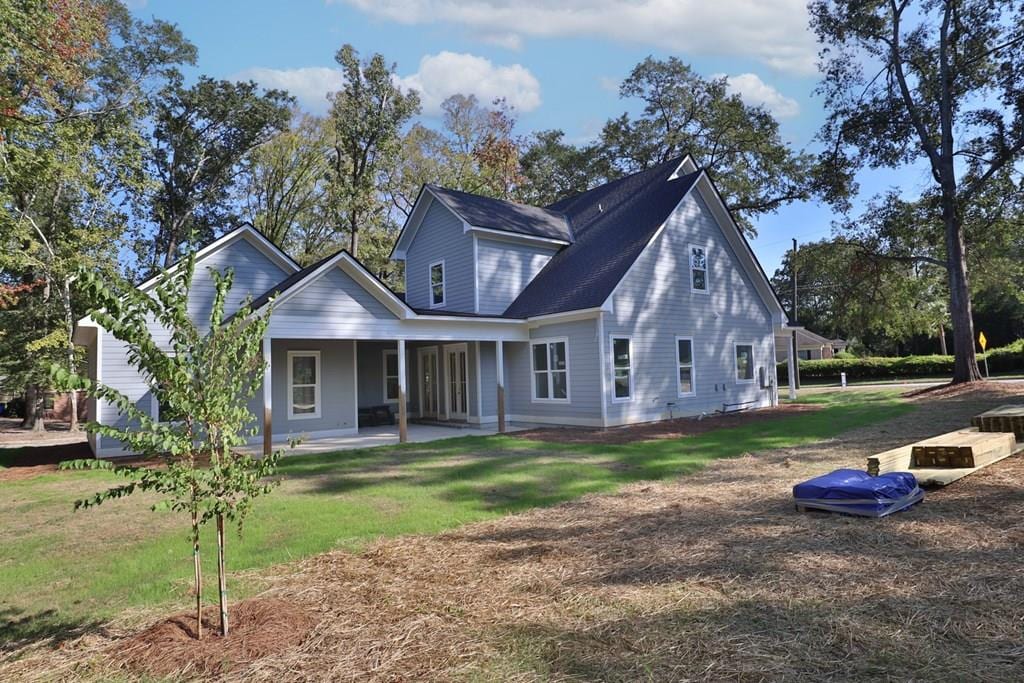 back of property featuring a lawn and a patio