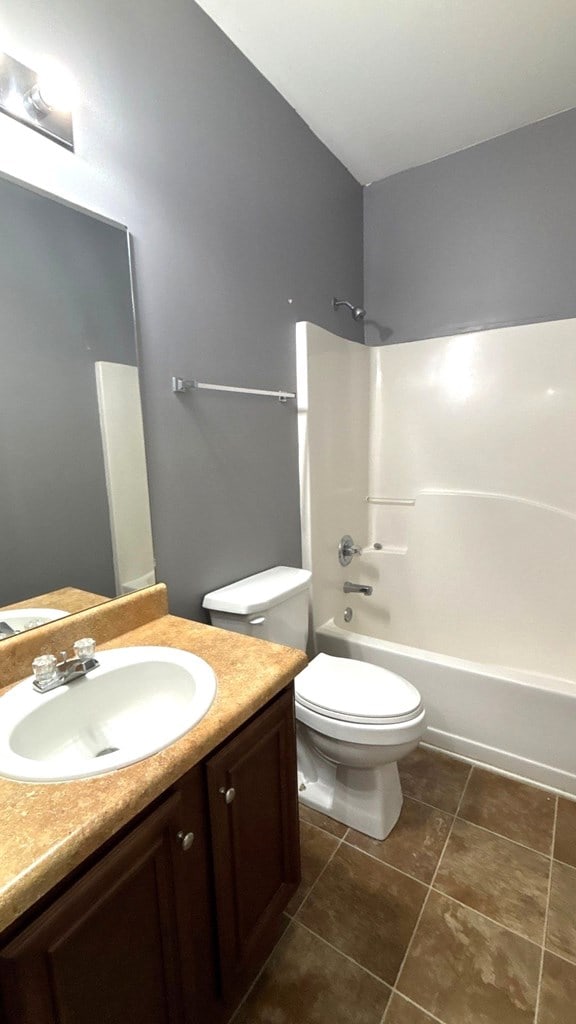 5 Rusty Dr, Phenix City, AL 36869 - bathroom featuring vanity, toilet, tile patterned floors, and tub / shower combination