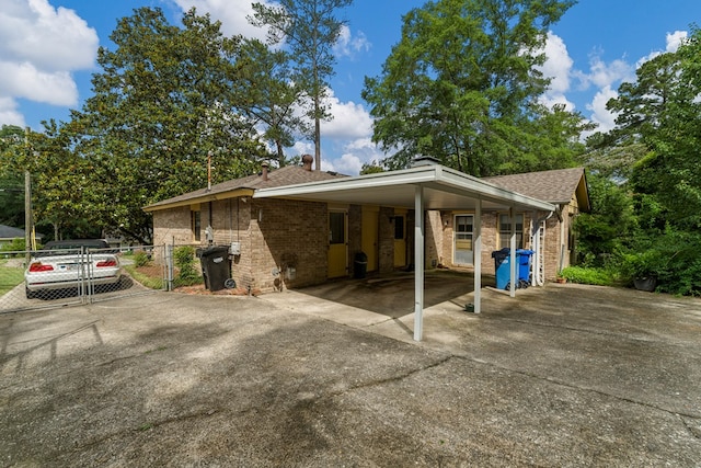 6256 Cricket Ln, Columbus, GA 31909 - back of property featuring driveway, brick siding, roof with shingles, a carport, and a chimney