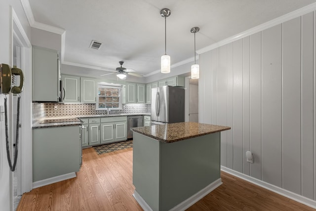 6256 Cricket Ln, Columbus, GA 31909 - kitchen featuring stainless steel appliances, light wood finished floors, a ceiling fan, backsplash, and a kitchen island
