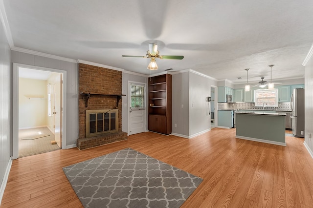 6256 Cricket Ln, Columbus, GA 31909 - unfurnished living room with a ceiling fan, light wood-type flooring, a brick fireplace, a sink, and baseboards