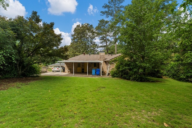 6256 Cricket Ln, Columbus, GA 31909 - rear view of house with a yard, brick siding, a chimney, and a carport