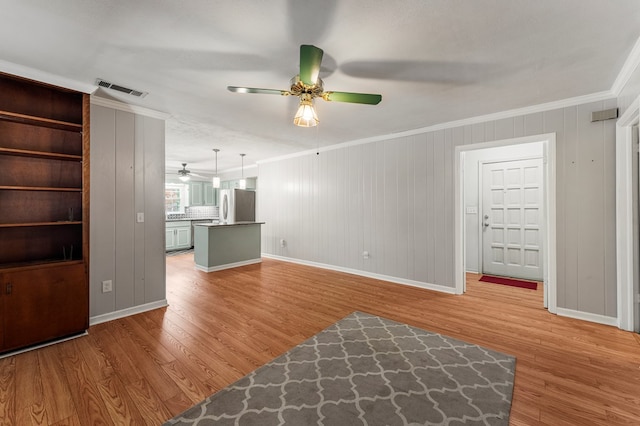 6256 Cricket Ln, Columbus, GA 31909 - unfurnished living room featuring a ceiling fan, crown molding, light wood-type flooring, and baseboards