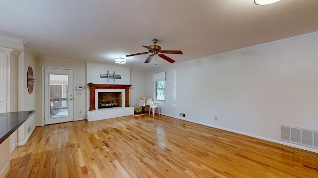 1225 Chaplin Dr, Columbus, GA 31904 - unfurnished living room featuring a brick fireplace, light wood-style floors, a ceiling fan, and ornamental molding