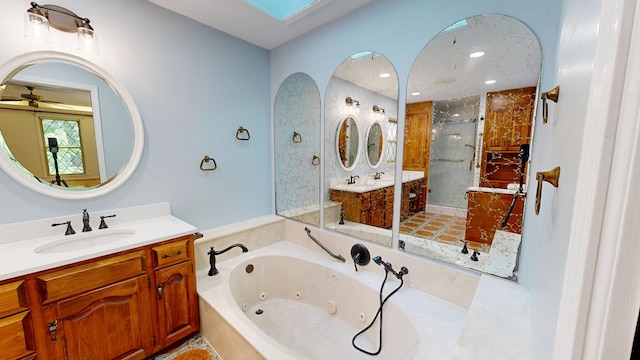 1225 Chaplin Dr, Columbus, GA 31904 - full bath with a stall shower, a tub with jets, two vanities, a ceiling fan, and a skylight