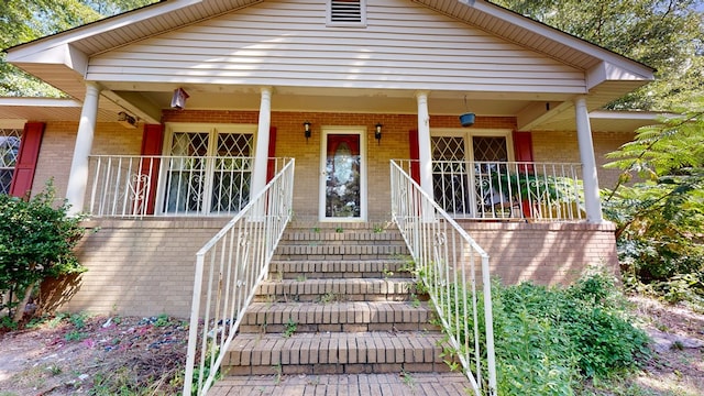 1225 Chaplin Dr, Columbus, GA 31904 - view of front facade featuring brick siding, covered porch, and stairs
