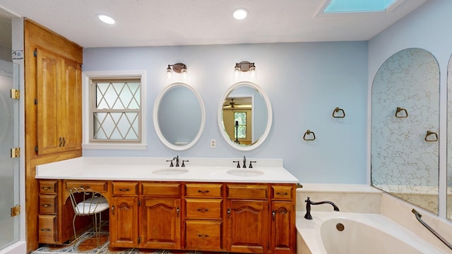 1225 Chaplin Dr, Columbus, GA 31904 - bathroom featuring a garden tub, double vanity, a shower with shower door, recessed lighting, and a skylight