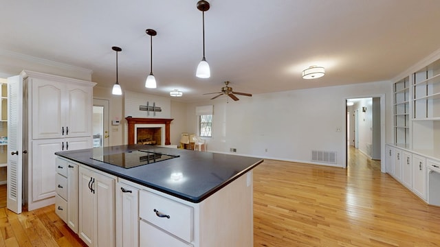 1225 Chaplin Dr, Columbus, GA 31904 - kitchen featuring black electric stovetop, dark countertops, open shelves, a fireplace, and light wood-style floors