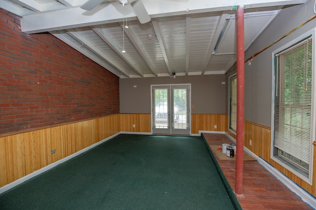 1609 4th Pl, Phenix City, AL 36869 - empty room featuring a wainscoted wall, wooden walls, a ceiling fan, french doors, and brick wall