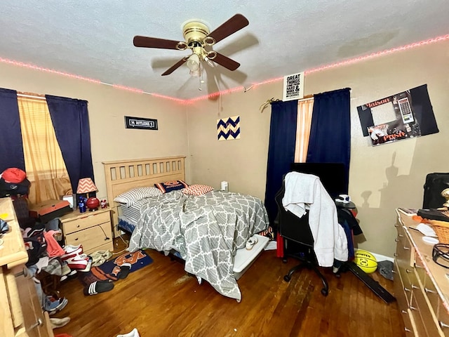 bedroom featuring ceiling fan, dark hardwood / wood-style floors, and a textured ceiling