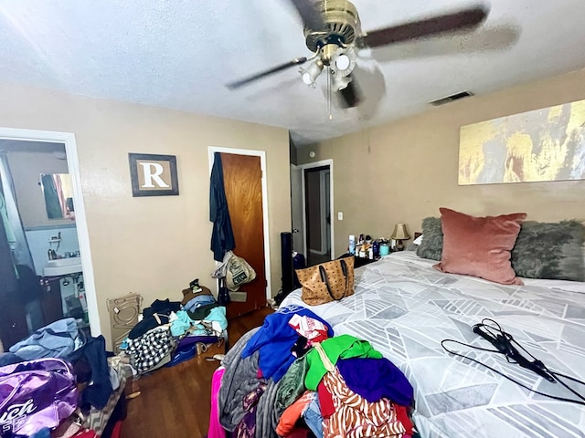 bedroom with connected bathroom, ceiling fan, and wood-type flooring