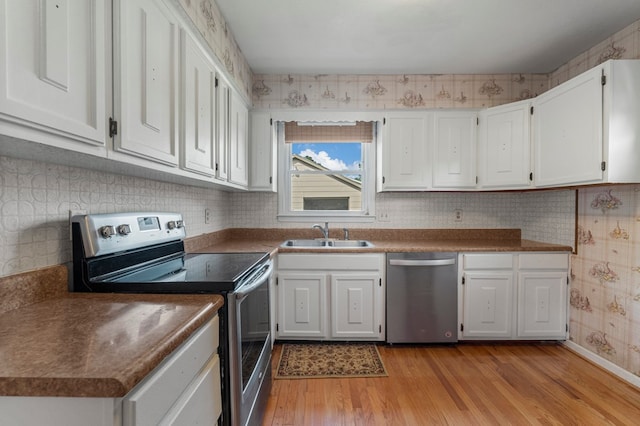 6248 Old Post Ct, Columbus, GA 31909 - kitchen featuring appliances with stainless steel finishes, white cabinetry, light wood-style flooring, dark countertops, and wallpapered walls