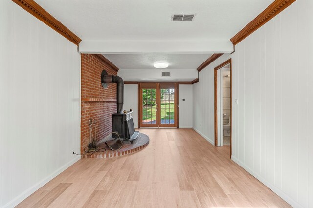 6248 Old Post Ct, Columbus, GA 31909 - unfurnished living room with a wood stove, light wood finished floors, and crown molding