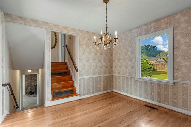 6248 Old Post Ct, Columbus, GA 31909 - unfurnished dining area with wood finished floors, a chandelier, stairway, and wallpapered walls