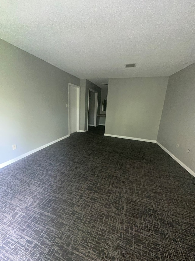 carpeted spare room featuring a textured ceiling