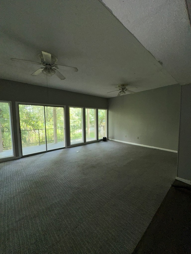 carpeted spare room featuring a textured ceiling and ceiling fan