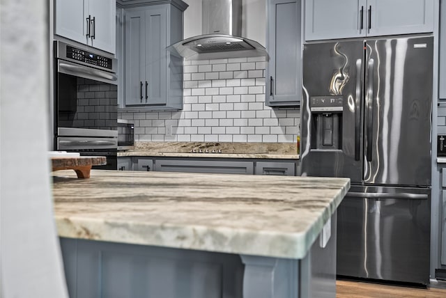 5784 Ga Highway 0355, Box Springs, GA 31801 - kitchen with appliances with stainless steel finishes, wall chimney range hood, tasteful backsplash, and light stone countertops