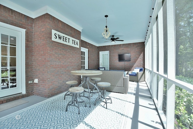 sunroom / solarium featuring ceiling fan