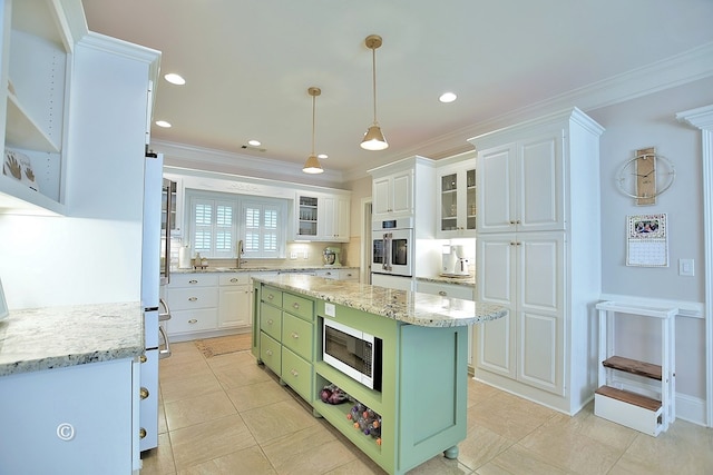 kitchen featuring light stone counters, crown molding, white cabinets, a center island, and green cabinets