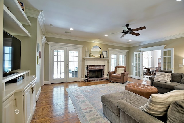 living room featuring french doors, light hardwood / wood-style flooring, ceiling fan, and crown molding