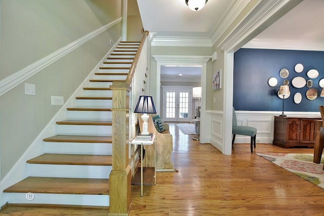 entrance foyer featuring crown molding, french doors, and light hardwood / wood-style floors