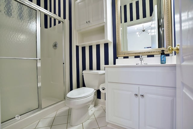 bathroom featuring vanity, tile patterned floors, toilet, walk in shower, and a notable chandelier