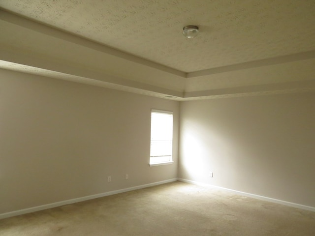 unfurnished room with baseboards, light carpet, and a textured ceiling