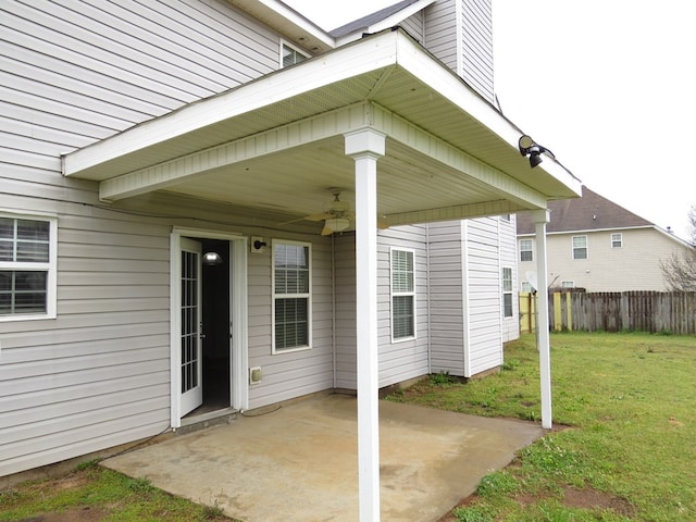 view of exterior entry featuring a patio, a yard, fence, and ceiling fan