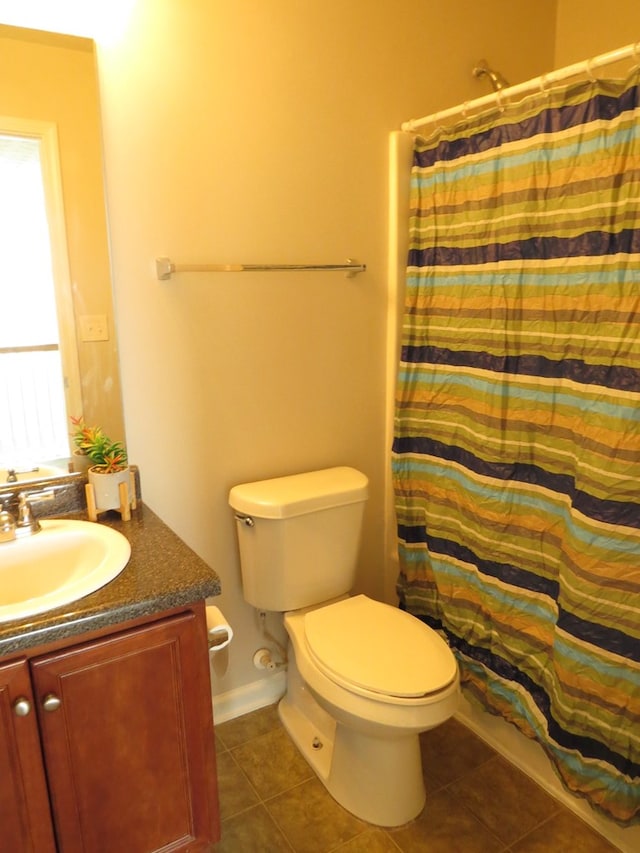 bathroom with tile patterned floors, a shower with curtain, toilet, and vanity