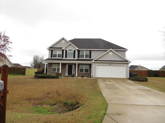 traditional home with an attached garage, concrete driveway, a front lawn, and fence