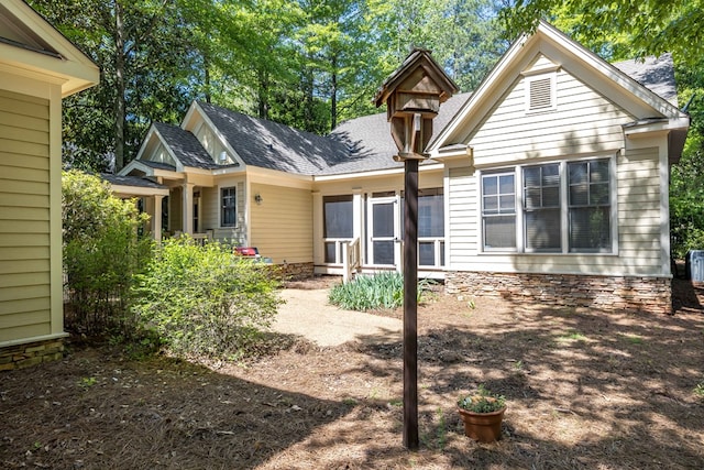 back of property featuring roof with shingles