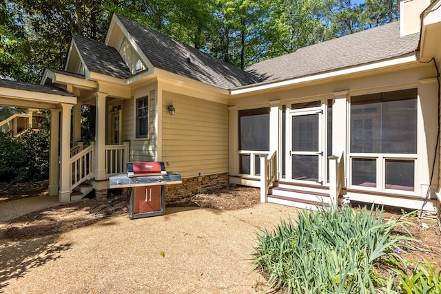 back of property with a shingled roof, a chimney, and entry steps