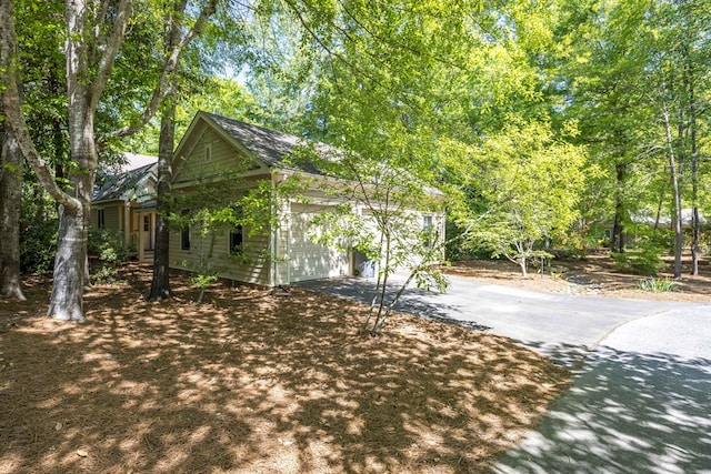 view of side of home with aphalt driveway and a garage