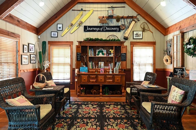 sitting room featuring wood finished floors, vaulted ceiling with beams, and wooden walls